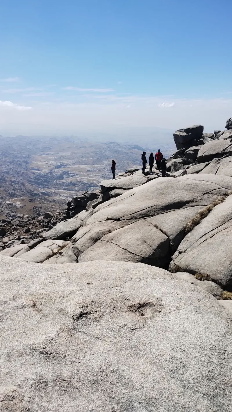 Excursionistas sobre las rocas del Champaquí con vistas a las Sierras Grandes